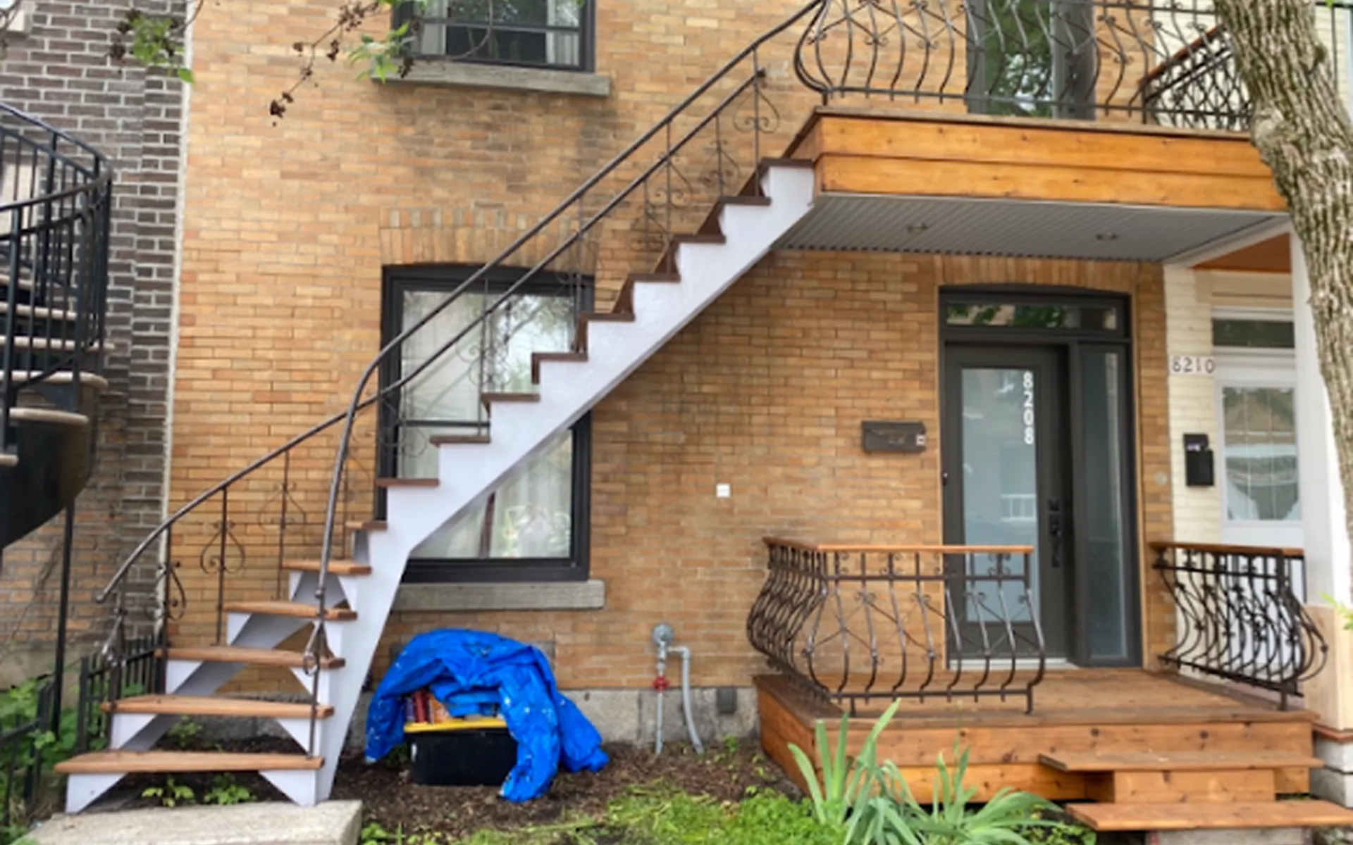 Duplex en brique avec escalier extérieur en fer forgé repeint