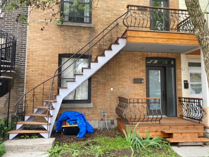 Duplex en brique avec escalier extérieur en fer forgé repeint