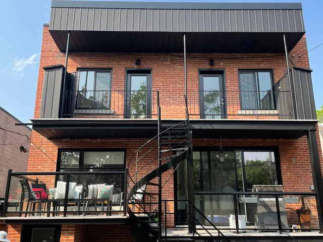 Immeuble en brique avec balcons et escalier en colimaçon noirs