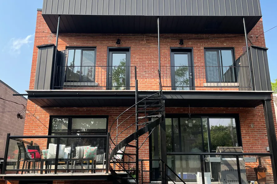 Immeuble en brique avec balcons et escalier en colimaçon noirs