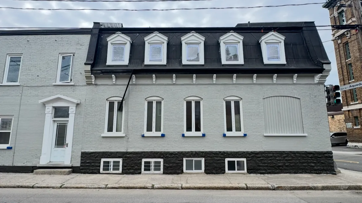 Maison grise à toit mansardé après la peinture extérieure