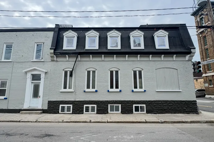Maison grise à toit mansardé après la peinture extérieure