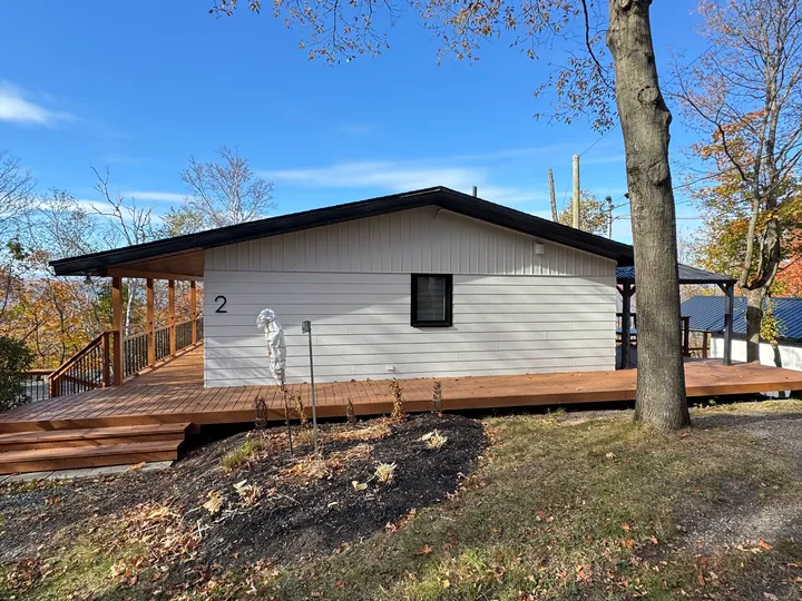 Maison blanche avec grande terrasse en bois teint